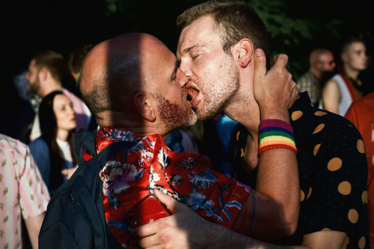 Zwei Männer küssen sich auf einer queeren Party in Berlin.
